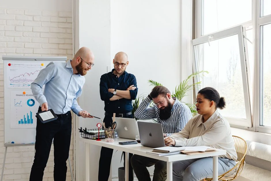 A diverse team collaborating on digital marketing strategies at a desk, using laptops and tablets.